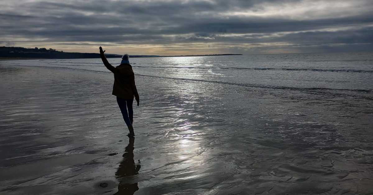 Silhouette of woman on beach, happy after her divorcce
